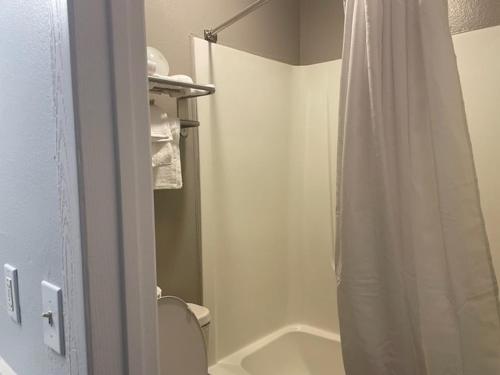 a bathroom with a shower curtain and a toilet at Studio 6 Rock Springs WY Flaming Gorge in Rock Springs