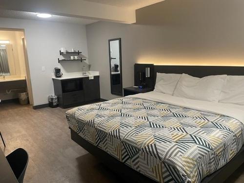a hotel room with a bed and a mirror at Studio 6 Rock Springs WY Flaming Gorge in Rock Springs