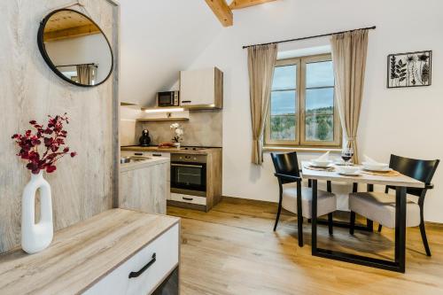 a kitchen with a table and a dining room at Penzion Zvon in Horní Stropnice