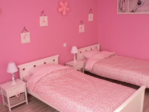 - 2 lits dans une chambre rose aux murs roses dans l'établissement Villa 216m2, 7ch, 15 pers : piscine, spa, billard, à Pujols