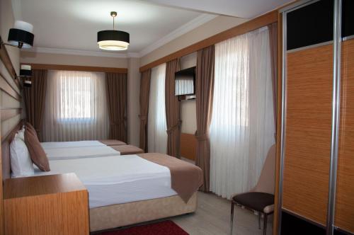 um quarto de hotel com uma cama e uma cadeira em Quars Garden Hotel em Koçyazı