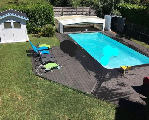 - une piscine avec 2 chaises longues et une table dans l'établissement Villa 216m2, 7ch, 15 pers : piscine, spa, billard, à Pujols