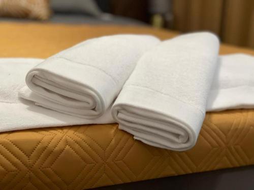 dos toallas blancas sentadas encima de una cama en Apartament Elisabeth BLUE I, en Pogórze