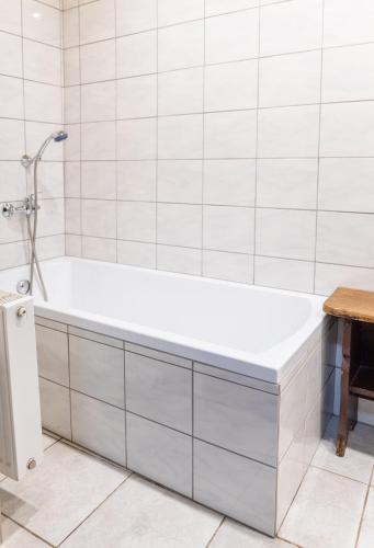 a white bathroom with a tub and a table at Chalupa Na Paloučku in Orlické Záhoří 
