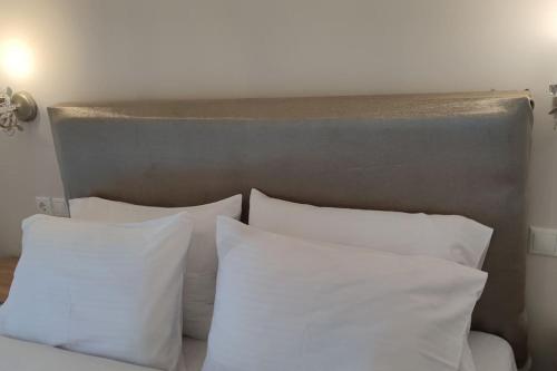 a white bed with white pillows in a bedroom at Η πέρλα της λίμνης/ The lake's pearl in Ioannina