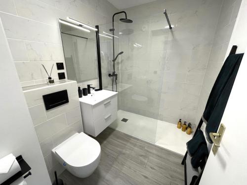 bagno bianco con servizi igienici e doccia di NEW Studio, piscine et vue mer • proche de Monaco a Beausoleil