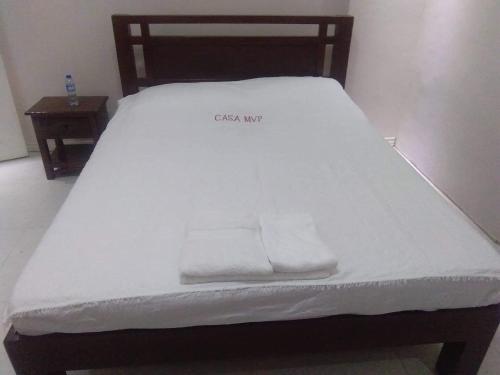 a bed with white sheets and two towels on it at Melvince Lodging House in Vigan