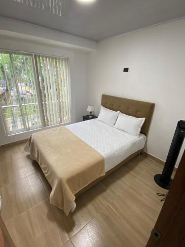 a bedroom with a bed with white sheets and two windows at Apto con aire acondicionado BUGA VALLE in Buga