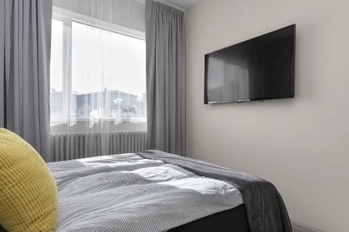 a bedroom with a bed and a flat screen tv at NN Urban Guesthouse in Reykjavík