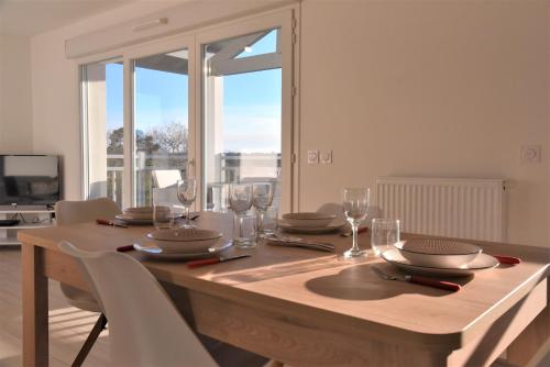 - une table en bois avec des verres et des assiettes dans l'établissement Domaine de Milhà, à Labenne