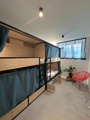 Cette chambre comprend 2 lits superposés et une chaise rouge. dans l'établissement YASI Hostel, à Lyon