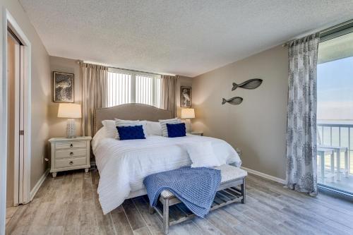 1 dormitorio con 1 cama grande con almohadas azules en Pensacola Beach Vacation Rental with Private Balcony, en Gulf Breeze