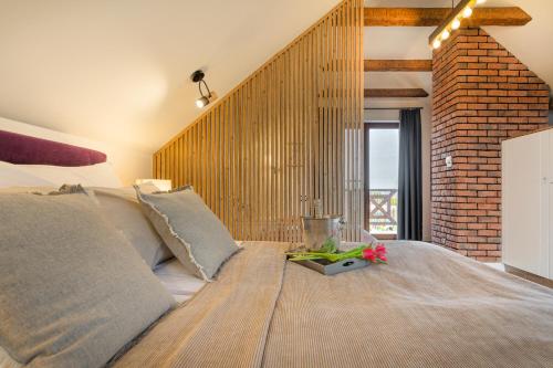 a bedroom with a large bed with a brick wall at Domki Mazurska Dolina in Mikołajki
