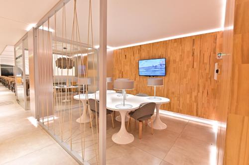 a dining room with two tables and a tv on a wall at Hotel Denver Mar del Plata in Mar del Plata