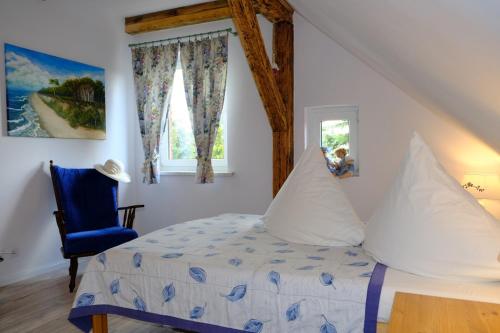 a bedroom with a bed and a blue chair at Siedlisko Egniu Agroturystyka nad jeziorem Pojezierze Drawskie in Żabinek