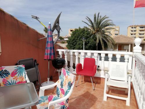 een balkon met stoelen en een parasol op een gebouw bij Casa Kalani in Playa Honda