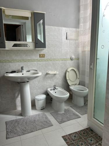 ein Badezimmer mit einem Waschbecken, einem WC und einem Spiegel in der Unterkunft Casa Passamonte in Palermo