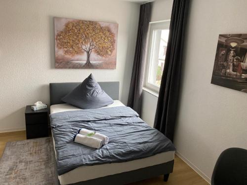 um quarto com uma cama com uma pintura de árvore na parede em 1 Zimmer Wohnung mit Bad em Trossingen