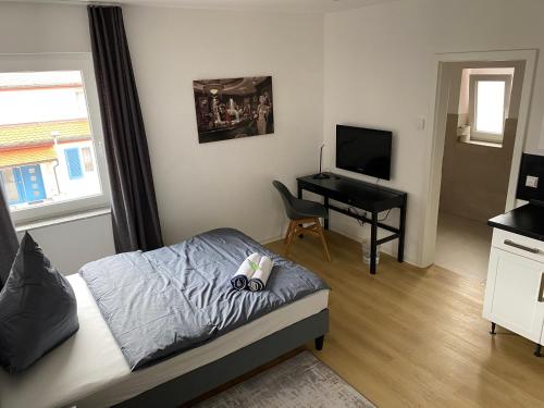 a bedroom with a bed and a desk with a television at 1 Zimmer Wohnung mit Bad in Trossingen