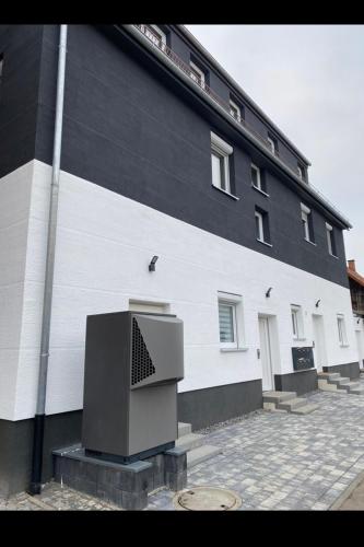 a black and white building with a tv in front of it at 1 Zimmer Wohnung mit Bad in Trossingen