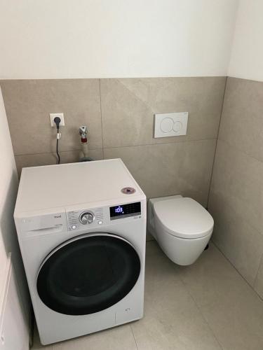 een kleine badkamer met een wasmachine en een toilet bij 1 Zimmer Wohnung mit Bad in Trossingen
