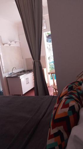 a room with a bed and a kitchen with a window at Pousada Bom Sucesso 59 in Olinda