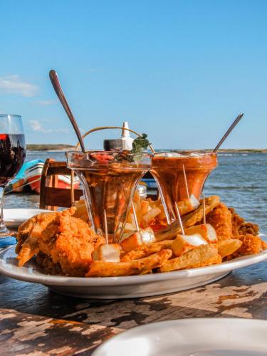 a plate of food on a table next to the water at Hotel Restaurante Spa La Barca de Oro in Las Peñitas
