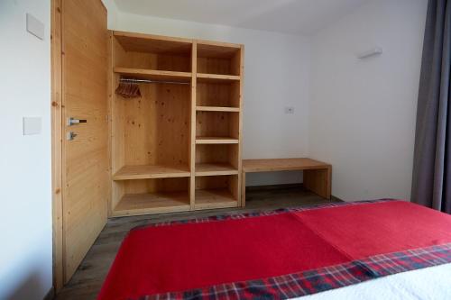 a room with a book shelf and a red rug at Al Bait Ross in Bormio