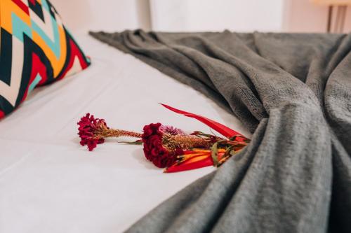 a pile of dead flowers laying on a bed at Pousada Bom Sucesso 59 in Olinda