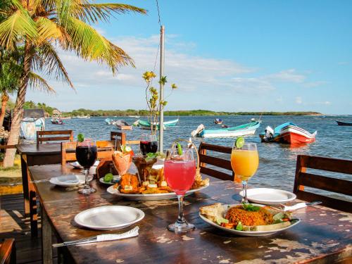 Hotel Restaurante Spa La Barca de Oro في لاس بينيتاس: طاولة مع أطباق من الطعام وكؤوس من النبيذ