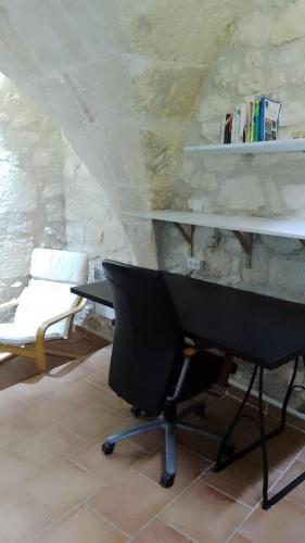 - un piano noir dans une pièce dotée d'un mur en pierre dans l'établissement Maison Troglodyte en Provence, à Fontvieille