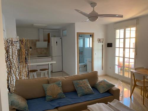Una sala de estar con un sofá y una cocina. en Ático en Barbate, en Barbate