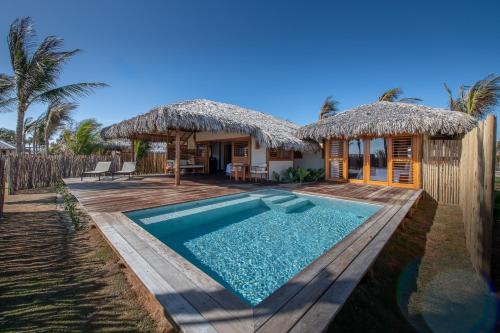 a villa with a swimming pool and a resort at Jaguaríndia Village in Fortim