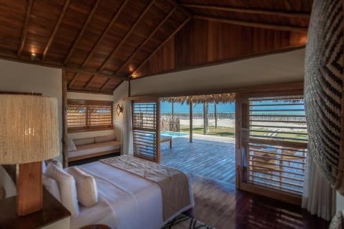 a bedroom with a bed and a view of the ocean at Jaguaríndia Village in Fortim