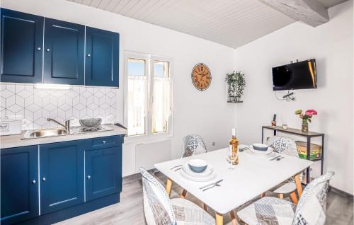 une cuisine avec des placards bleus et une table avec des chaises dans l'établissement 1 Bedroom Stunning Home In Bélesta, à Bélesta