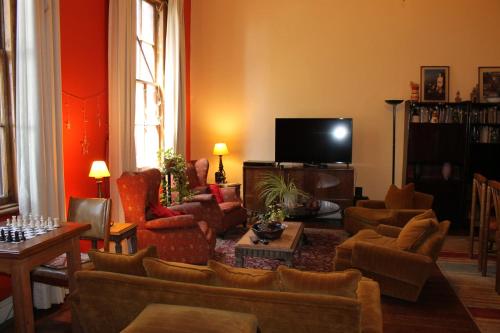 a living room with couches and a flat screen tv at Hostal Residencia en el Cerro in Valparaíso