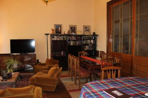 a living room with a table and chairs and a television at Hostal Residencia en el Cerro in Valparaíso