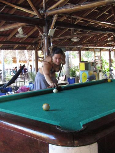 a woman is playing a game of pool at Hotel Restaurante Spa La Barca de Oro in Las Peñitas