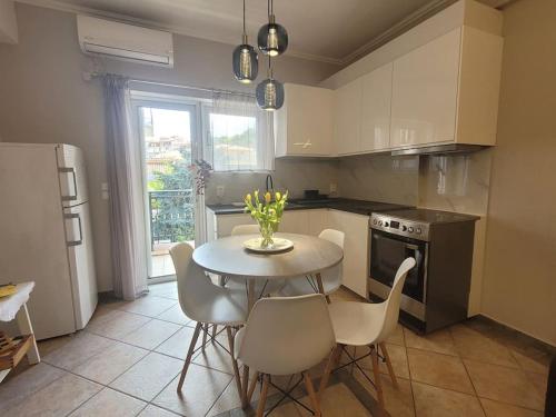 een keuken met een tafel en stoelen en een keuken met een raam bij Lovely Meteora Home in Kalabaka