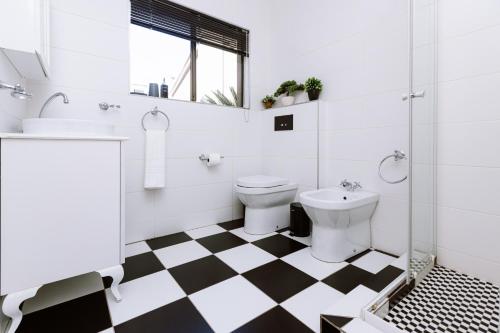 a bathroom with a black and white checkered floor at Pablo House in Johannesburg