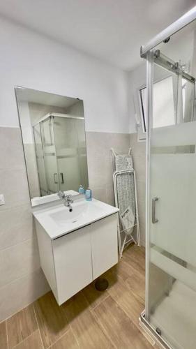 y baño con lavabo blanco y espejo. en Rockside Residences Suites La Línea N3, en La Línea de la Concepción