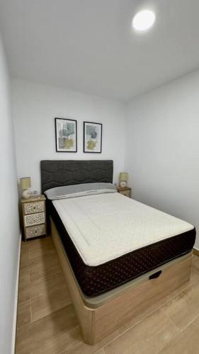 a bed in a room with two pictures on the wall at Rockside Residences Suites La Línea N3 in La Línea de la Concepción
