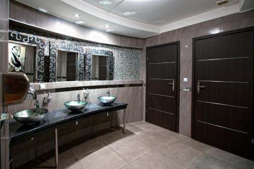 a bathroom with two sinks and two mirrors at Hotel Gold in Dębica