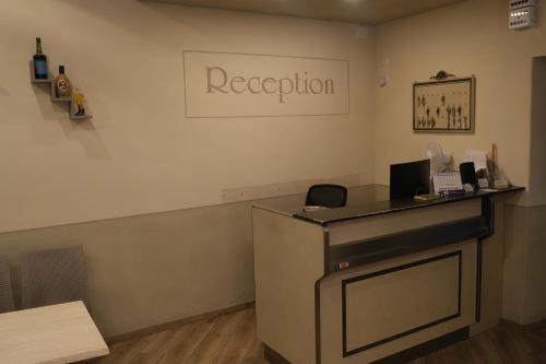 MomignoにあるAmelia Hotelの壁に看板が付いた客室内のフロントデスク