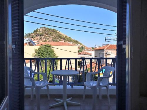 a patio with three chairs and a table on a balcony at Anthemis Studios in Skala Eresou
