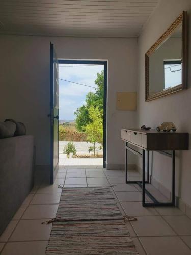 a room with a table and a mirror and a door at Casa da Laranjeira, perto de Obidos, Budha Eden, Dinossauros parque in Vale Covo