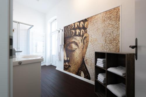 a bathroom with a mural of a face on the wall at Maritas Logierhaus (Haus Braunschweig) in Westerland