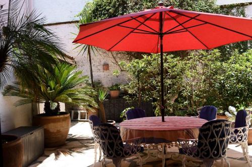 a table with a red umbrella on a patio at Agradable Cuarto de Hostal sobre el Centro, Valle in Valle de Bravo