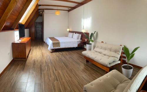 a bedroom with a bed and a couch and a tv at Riosol Hotel Laguna Azul in Sauce
