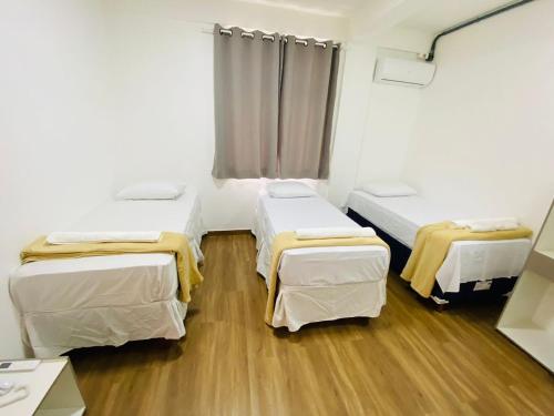 a room with two beds in a hospital room at Hotel Santorine Plaza - By UP Hotel in Itabira